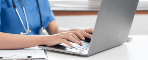 A veterinarian typing on a laptop.